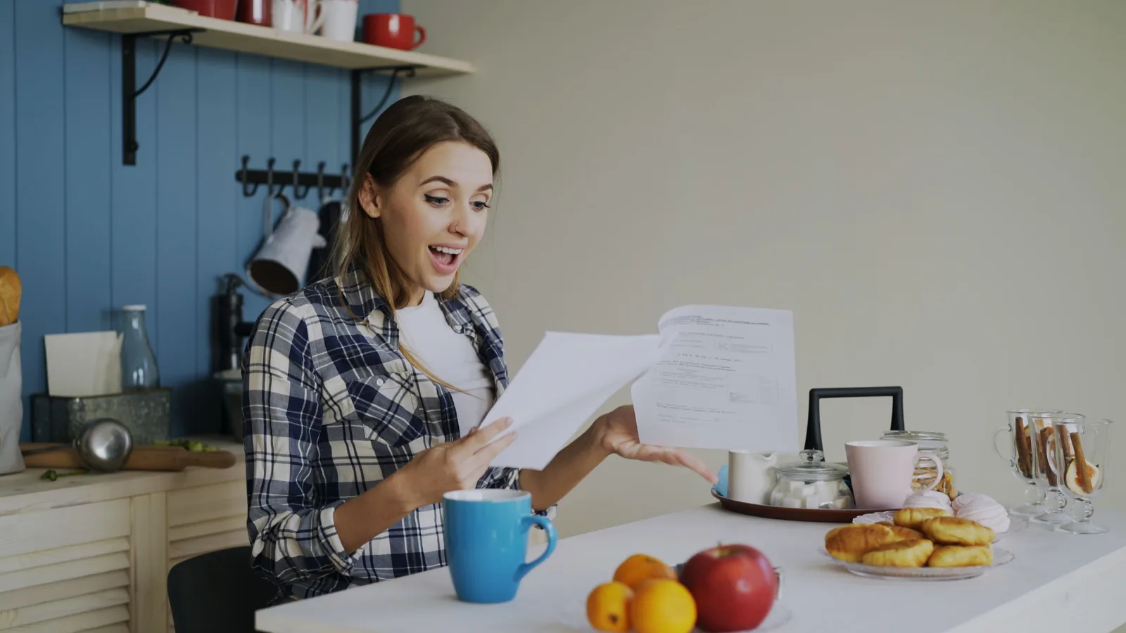 Person reviewing finances hopefully at the kitchen table